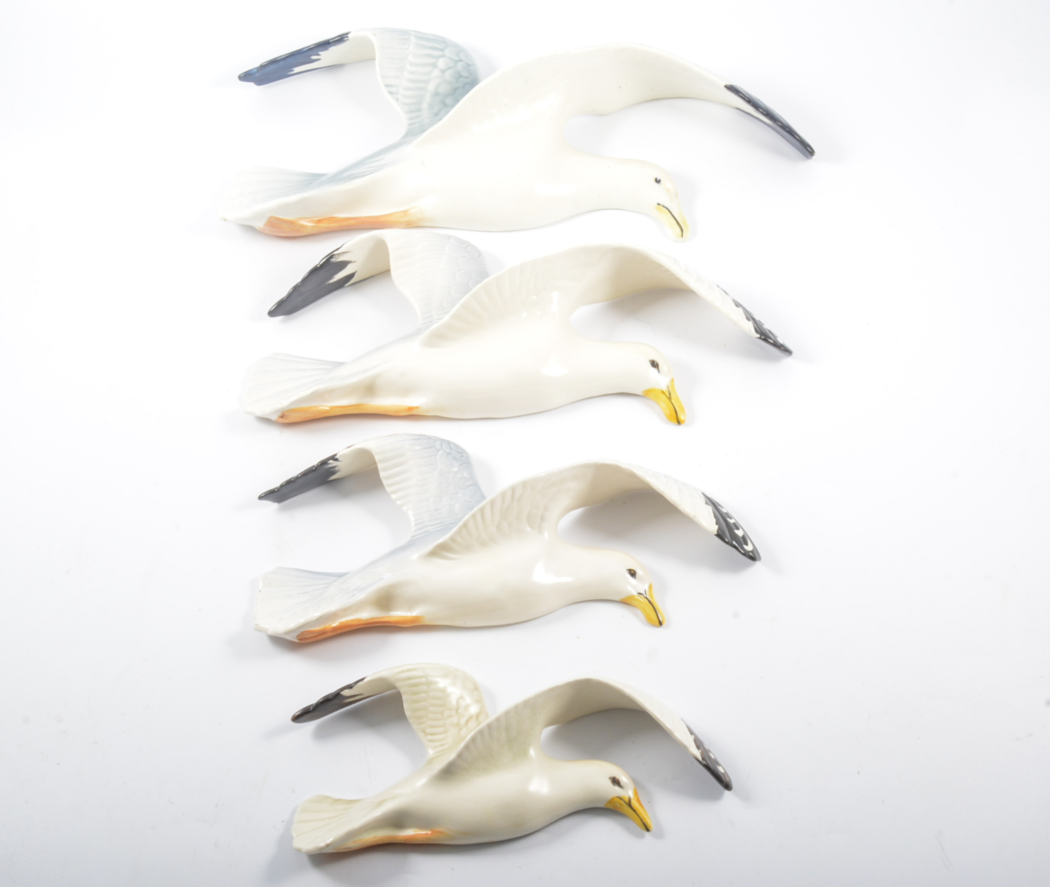 Set of four Beswick graduated seagulls and another pottery bird plaque.