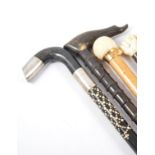 An Edwardian hardwood and ivory mounted short stick, pommel designed as a hand holding a bale, 67cm,