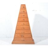Hardwood pyramid chest of nine graduating drawers, plynth base,