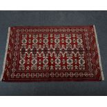 Kilim / Persian rug, with three rows of six guls joined by poles, against a crimson ground,