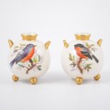 Pair of Worcester spherical vases, each with twin handles raised on three ball feet,