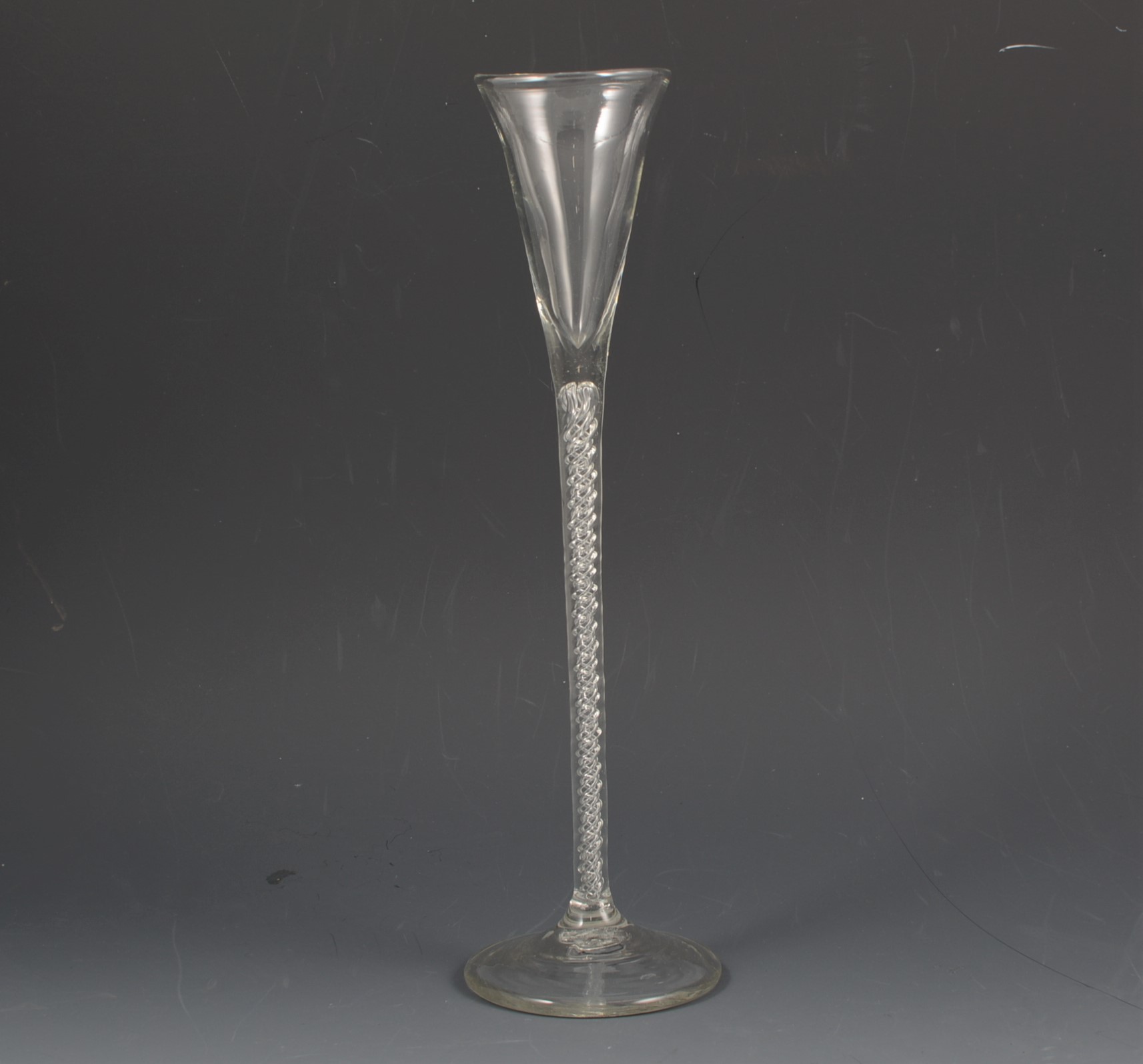 Tall glass ale flute, tapering straight-sided bowl, four strand air-twist stem, circular foot,
