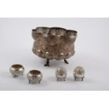 An Indian white metal bowl, two salts and two pepper pots,