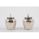 Two octagonal white metal canisters, polished finish embossed with flowers, recess for spoon,