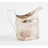 A George III silver cream jug, oval form with a zig zag border and vacant cartouche,