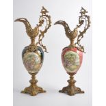 Pair of French gilded metal pedestal ewers, with pottery bodies.