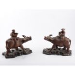 Pair of Chinese carved hardwood models, water buffalos, each ridden by a man, carved bases, 22cm.