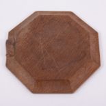 Robert 'Mouseman' Thompson of Kilburn, a small oak octagonal bread board, carved signature mouse,