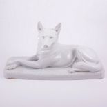Bohumil Rezl, an Art Deco porcelain study of a dog, modelled reclined on a naturalistic base,