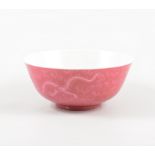 A Chinese porcelain bowl, pink ground exterior incised with dragons and pearls above waves,