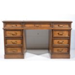 Eastern hardwood twin pedestal desk, fitted with nine drawers, width 133cm, depth 61cm, height 75cm.