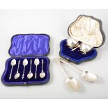 A set of six silver teaspoons, Apostle handles, cased, a box with four napkin rings,