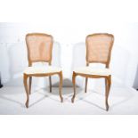 Four French beech salon chairs, shield-shape backs, with cane panels, serpentine upholstered seats,