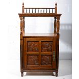 Aesthetic movement oak cabinet with carved panels, bobbin turned gallery back, above an open shelf,