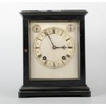 An Edwardian ebonised mantel clock, the case with moulded outlines, silvered dial,