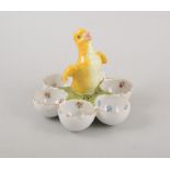Continental porcelain cruet for six eggs, the handle modelled as a yellow chick, 13cm.