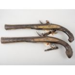 A near pair of antique Afghan flintlock pistols, the barrels 28cm, with silver Damascene patterns,