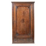 George III style oak hanging corner cupboard, with a panel door over three dummy drawers.