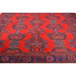 Turkish carpet, lozenge medallions on a red ground, broad border, 355 x 272cm.