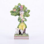 Staffordshire pearl glazed earthenware bocage figure of a seated piper, circa.