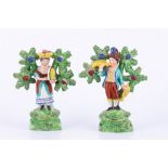 Pair of Staffordshire pearl glazed earthenware bocage figures, Showman and a girl with tambourine,