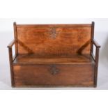 Oak box seat settle, carved decoration to the back, open arms, width 147cm.