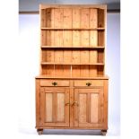 A pine dresser, panelled back with three shelves, later with a rectangular top, moulded edge,