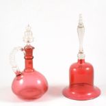 Victorian cranberry glass hand-bell, 31cm, and a cranberry claret jug.