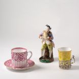 A Belleek porcelain woven basket with applied flower heads, a Belleek cup and saucer,