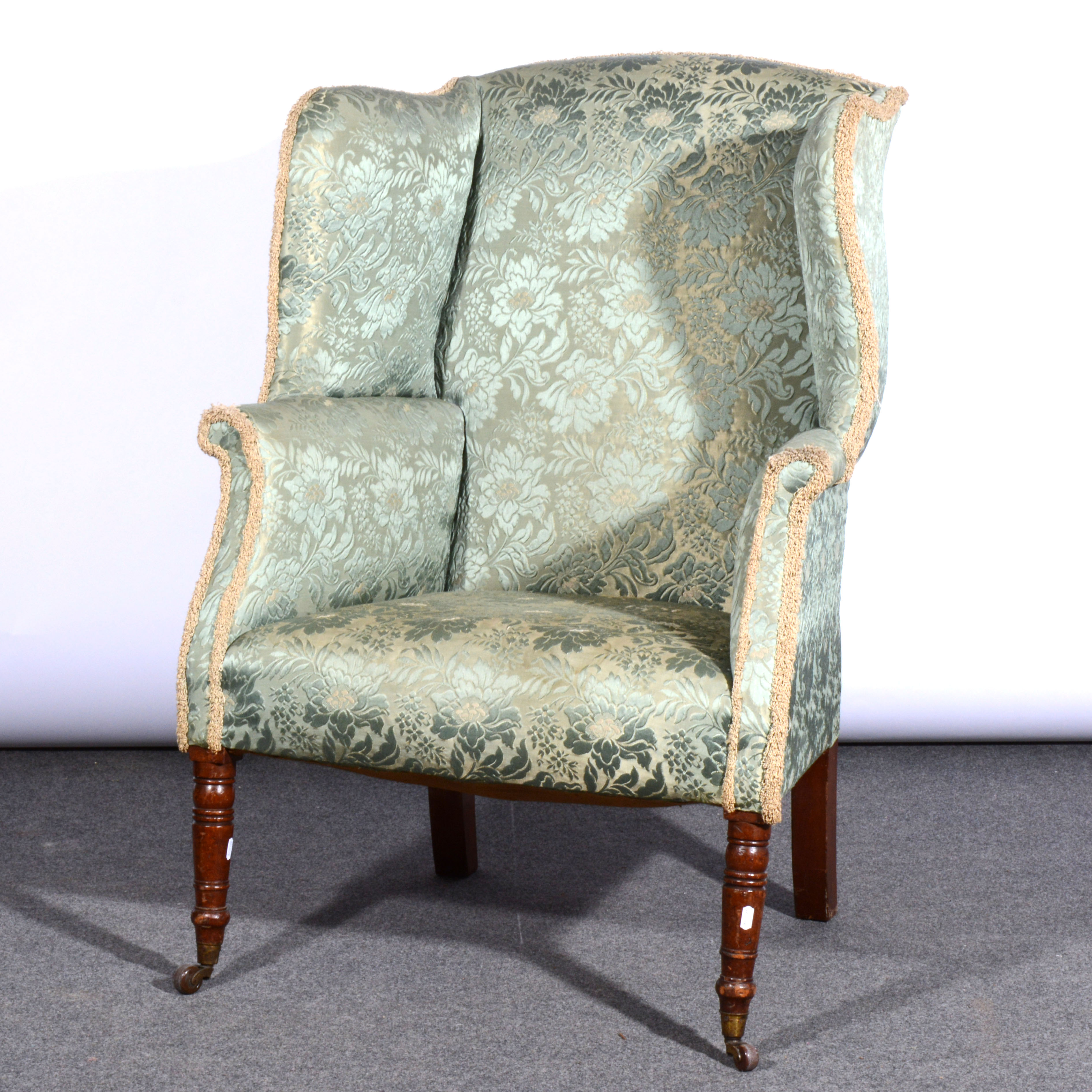 Victorian wing back chair, turned and ringed mahogany legs on castors, 78cm.
