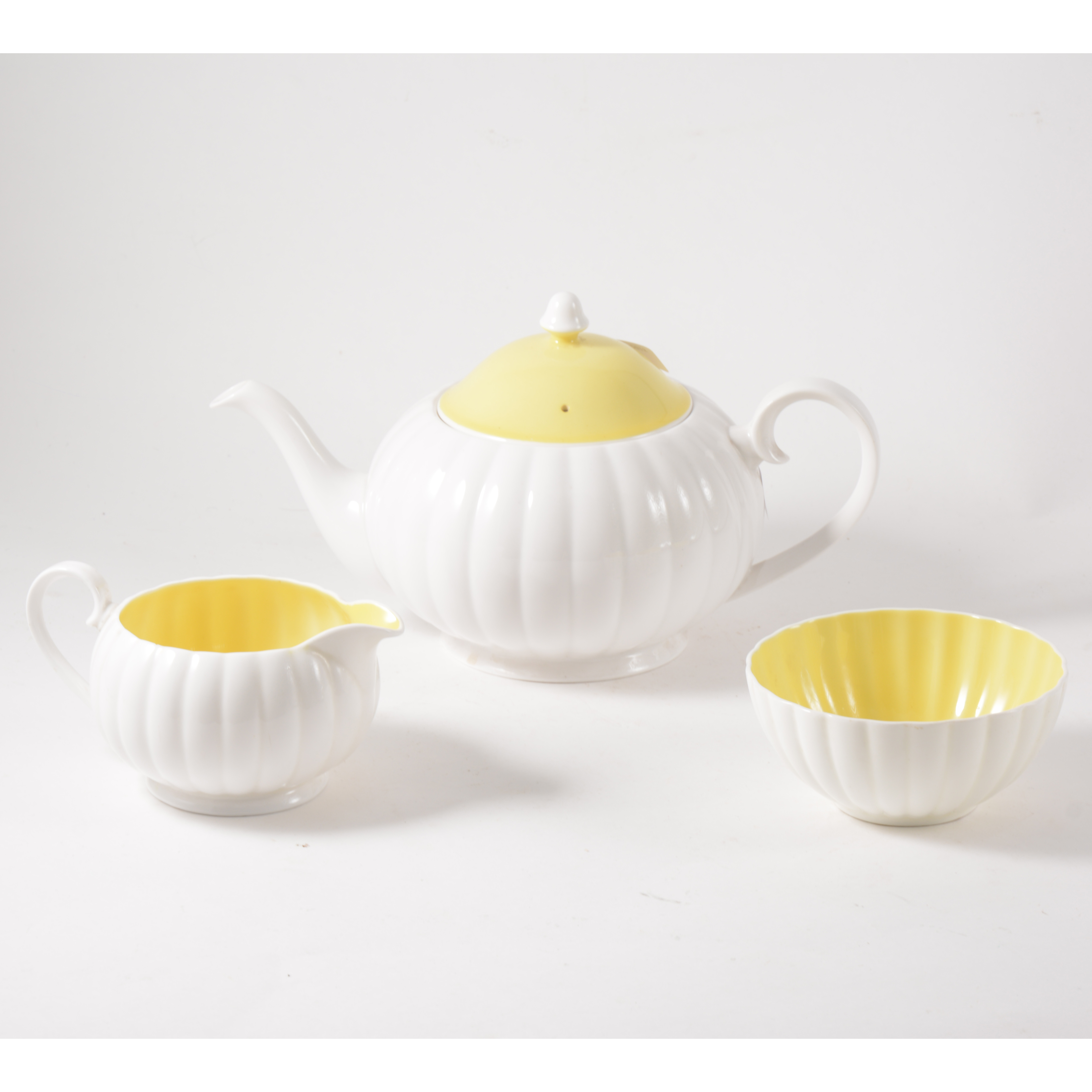 A Susie Cooper three piece teaset, white flute design with yellow interior and cover to teapot. - Image 2 of 3