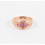 A lady's rose metal dress ring, nine untested pink stones set into a tapered band, shank marked 9ct,