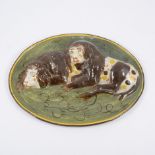 An early oval 19th Century plaque of two lions on a green ground, drilled at top, 27cm x 20cm.