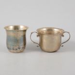 A small silver twin handled porringer, coin set into base, 7cm high, hallmarked Chester 1922,