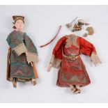 A pair of Chinese painted plaster models of a dignitary and his wife, each in silk robes,