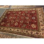 Kashan rug, red ground with allover floral field, broad borders, 357cm x 250cm.