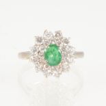 An emerald and diamond oval cluster ring, the oval mixed cut emerald 6.