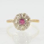 A ruby and diamond cluster ring, a small round cut ruby surrounded by seven old cut diamonds,