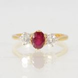 A ruby and diamond three stone ring, the oval mixed cut ruby 6mm x 4.