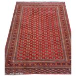 A Turkoman carpet, red ground with all over design of guls within multiple borders, 435x315cm.