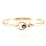 Tom Payne - A 9 carat yellow gold tension style bangle set with tourmaline,