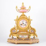 A Louis XV style gilt metal and Rose Pompadour porcelain mantel clock, 19th Century, urn finial,