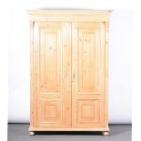 French pine wardrobe, moulded cornice, plain frieze, panelled doors enclosing hanging rail,