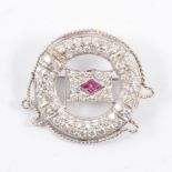 A white metal brooch on a nautical theme,