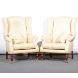 Pair of armchairs, Victorian style wing backs, turned stained wood legs, brass caps and castors,