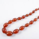 A string of simulated amber beads, the egg shaped beads graduating from 10mm to 25mm,
