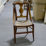 A beech child's chair, arched cresting, vase shape slat, rush seat, sabre legs, width 31cm.