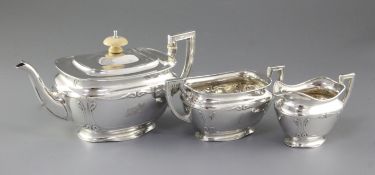 An Edwardian Art Nouveau matched silver three piece tea set, hallmarked London 1907/08 by