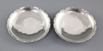 A pair of 1930's Arts & Crafts planished silver dishes, by Omar Ramsden, hallmarked London 1938,