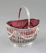A Victorian silver swing handled sugar basket with cranberry glass liner, by Nathan & Hayes,
